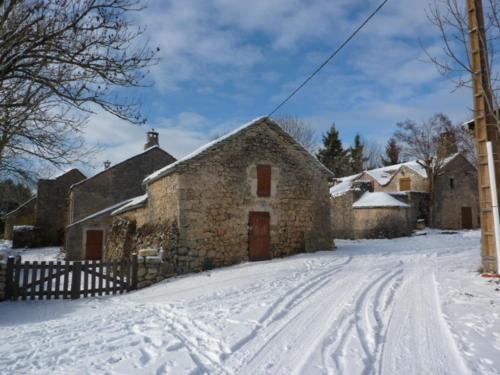 a stone building in the snow with a snow covered street at Le Passé Composé in Millau