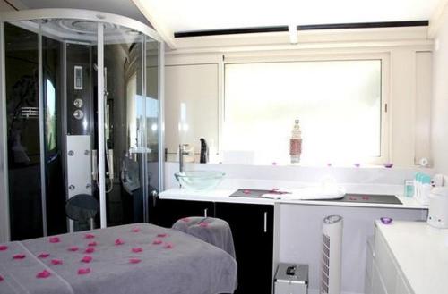 een keuken met een aanrecht en een tafel met roze bloemen erop bij Les Hauts de Lastours in Belvès