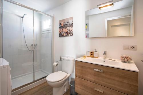 een badkamer met toilet, douche en wastafel bij Flower Beach Suite 23 in Playa Honda