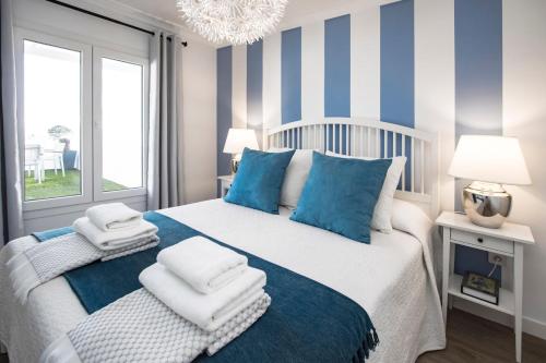 een slaapkamer met een bed met blauwe en witte strepen bij Flower Beach Suite 23 in Playa Honda