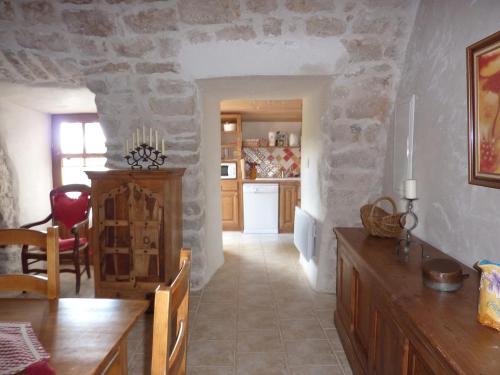 a kitchen and dining room with a stone wall at Le Passé Composé in Millau
