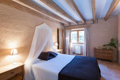 a bedroom with a bed with a canopy at Sa Casa Rotja in Sineu