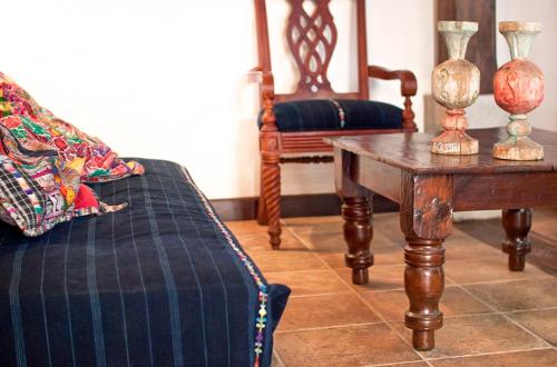 a room with a couch and a table with vases on it at Villas Santa Ana in Antigua Guatemala