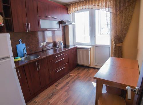a kitchen with wooden cabinets and a sink and a window at Квартира на березі Дніпра у новому будинку! in Cherkasy