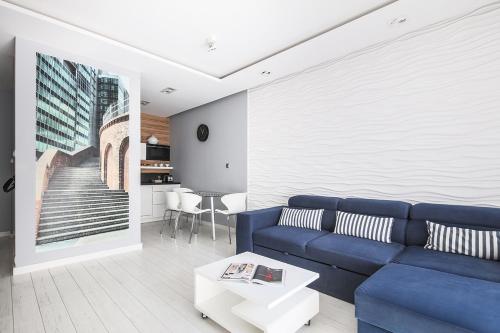 a living room with a blue couch and a table at Capital Apartments - Towarowa in Poznań