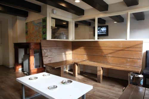 a wooden bench in a room with a table at International Budget Hostel City Center in Amsterdam