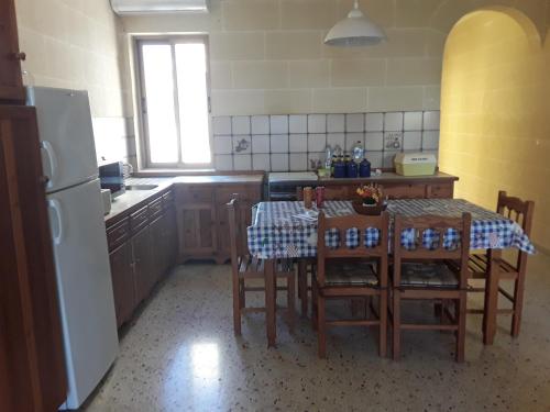 a kitchen with a table and chairs and a refrigerator at Felluga harbour view in Qala