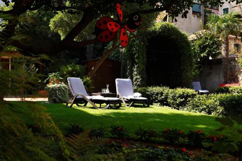 two chairs and a butterfly sitting on a lawn at Pensione Accademia - Villa Maravege in Venice
