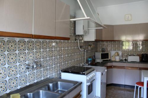 a kitchen with a sink and a stove at Casa de alojamento local (T2) Queluz de Baixo in Oeiras