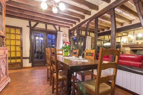 Un comedor con mesa y sillas de madera. en les riflets, en Conches-en-Ouche
