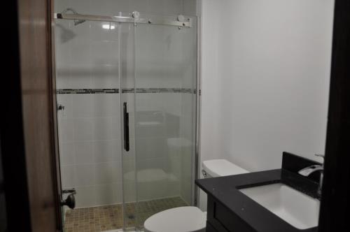 a bathroom with a shower with a toilet and a sink at Ambassador's Inn Next Door in Stratford
