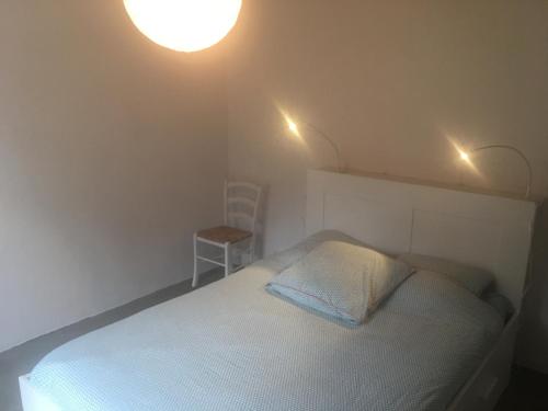 - une chambre avec un lit et deux lumières au plafond dans l'établissement Les Genets, à Ker borny