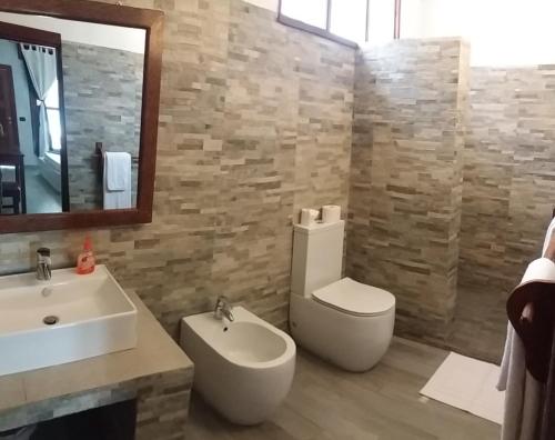 a bathroom with a sink and a toilet and a mirror at White Dream in Kiwengwa
