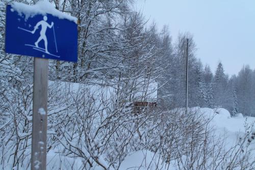 a blue sign with a skier on it in the snow at Maatilamatkailu Jänisvaara in Kolinkylä
