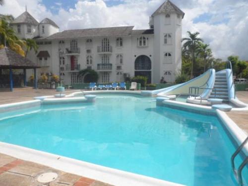 a swimming pool with a slide in front of a building at Dunn's Apartments at Sandcastles in Ocho Rios