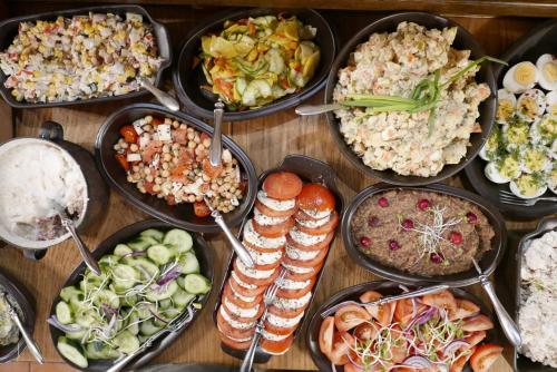 einen Tisch mit vielen verschiedenen Arten von Lebensmitteln in Pfannen in der Unterkunft Villa Greta in Schönau an der Katzbach