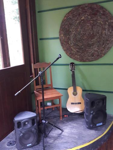 a room with a microphone and a guitar and a chair at Refúgio Ecológico Amadamata in Nova Friburgo