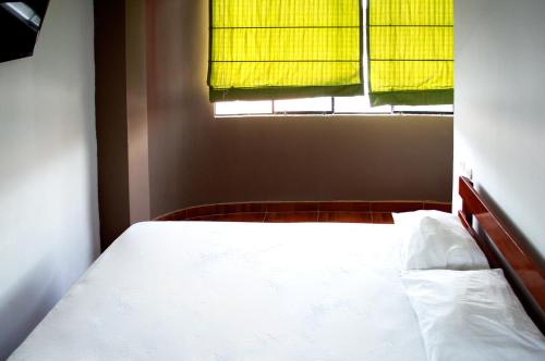 ein Schlafzimmer mit einem weißen Bett und einem Fenster in der Unterkunft Hostal Los Angeles in Barranca