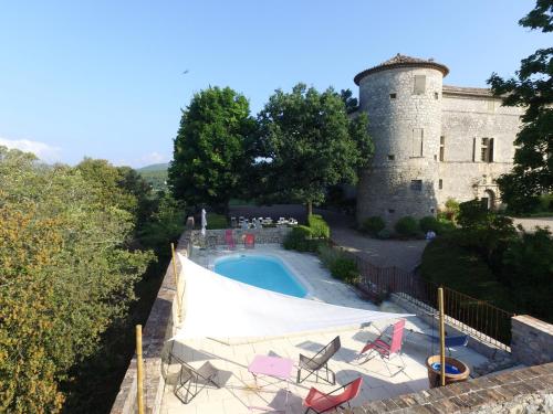 un château avec une piscine en face d'un bâtiment dans l'établissement Château de Rousson, à Rousson