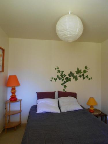 - une chambre dotée d'un lit avec deux oreillers et une lampe dans l'établissement la clairiere, à Sarlat-la-Canéda