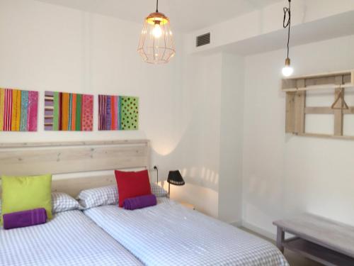 グラナダにあるRealejo Center Apartments 2 bedroomのベッドルーム1室(カラフルな枕付きのベッド1台付)