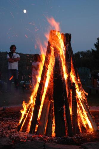 a man is standing next to a fire at Le Grand Lodge Mont Tremblant in Mont-Tremblant