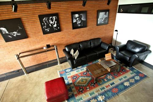 a living room with black leather furniture and a brick wall at Alfonsina Hotel Boutique in Santa Cruz de la Sierra