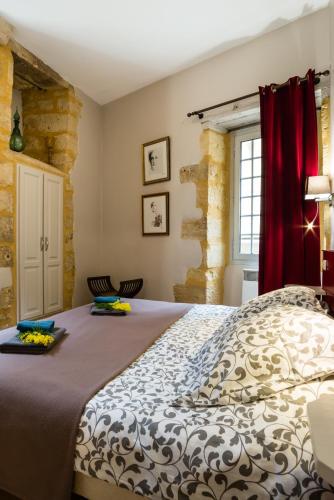 une chambre avec un lit et un rideau rouge dans l'établissement Rouge Passion, à Sarlat-la-Canéda