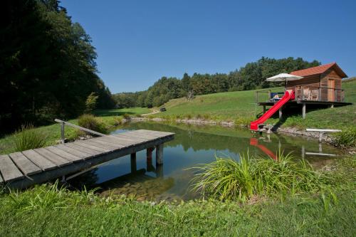a wooden bridge over a river with a house at Weingut Winzerhof Gästezimmer Grebenz in Großklein