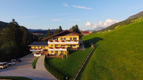a house on a hill with flowers on it at Landhaus Harmonie in Riezlern