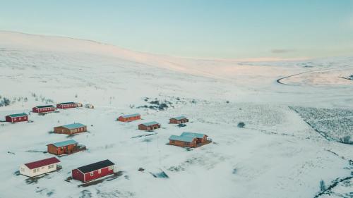 een groep huizen in een met sneeuw bedekt veld bij Guesthouse Brekka in Brekka