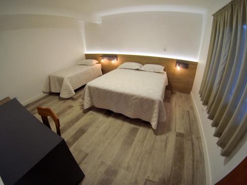 a hotel room with two beds and a window at Apartamento de Férias - Fernanda in Treze Tílias