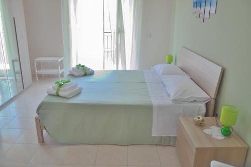 a bedroom with a large bed with towels on it at B&B Al Sole di Sicilia in Giardini Naxos