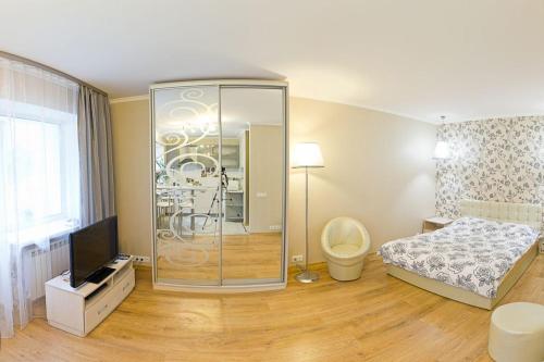 um quarto com um chuveiro, uma cama e uma televisão em Апартаменты рядом с центром em Kiev