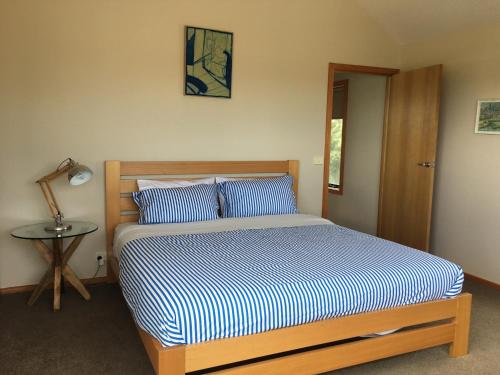a bedroom with a bed and a lamp and a table at Apostle Hideaway - Central Port Campbell in Port Campbell