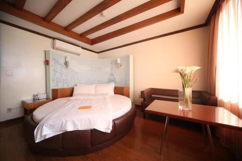 a bedroom with a bed with a vase on a table at Nova Motel in Boryeong