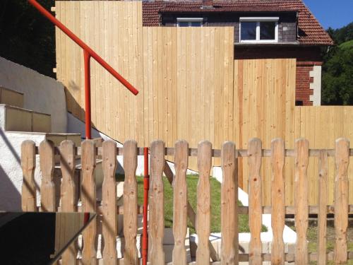 a wooden fence in front of a house at Direkt am Main in Karlstadt
