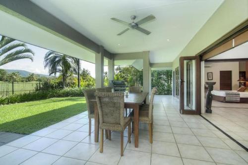 uma sala de jantar com mesa e cadeiras em Tranquility By The Course Port Douglas em Port Douglas