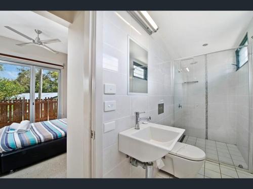 a white bathroom with a sink and a toilet at Crescent Head Spa Villa in Crescent Head