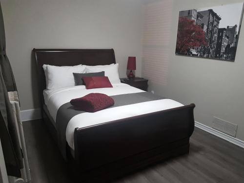 um quarto com uma cama grande e uma almofada vermelha em 1-Bedroom Cozy Suite #23 by Amazing Property Rentals em Gatineau