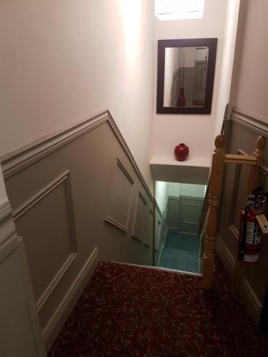 a hallway with a stairway with a mirror on the wall at 1-Bedroom Cozy Suite #23 by Amazing Property Rentals in Gatineau
