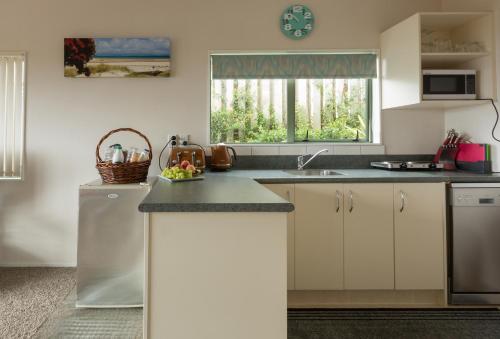 a kitchen with white cabinets and a counter top at Ocean View B&B in Whitianga