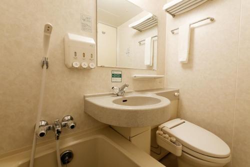 a small bathroom with a sink and a toilet at Kurume Washington Hotel Plaza in Kurume