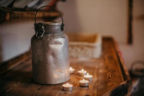 an old jar with candles on a wooden table at Maso Del Fieno con Sauna Privata e Vista Unica in Sant'Orsola Terme