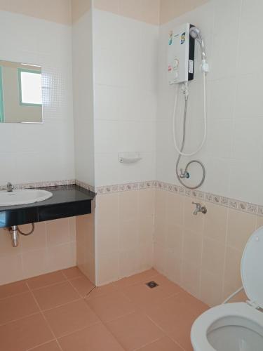 a bathroom with a shower and a toilet and a sink at Baanpak Sam Anong in Hua Hin