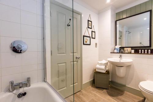 a bathroom with a tub and a sink and a toilet at The Brewers Inn in London