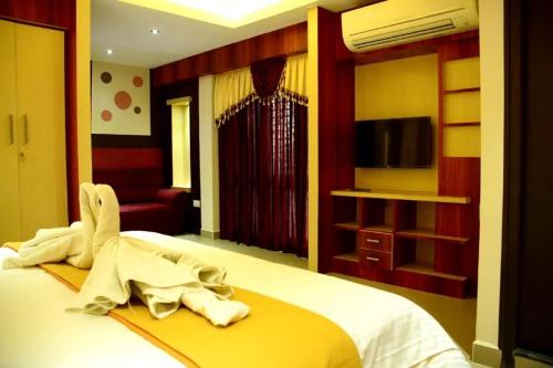 una camera d'albergo con un letto e un accappatoio. di Star MSR Residency a Perambalūr