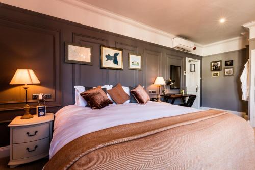 um quarto com uma cama grande e 2 candeeiros em The Brewers Inn em Londres