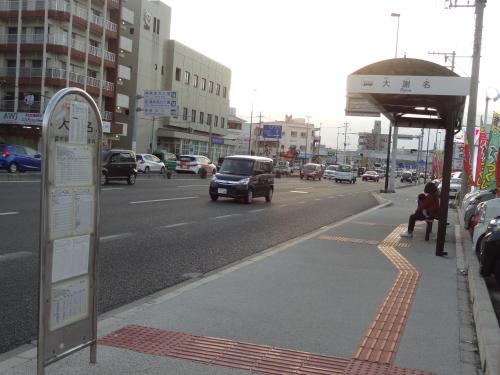 a bus stop with a sign on the side of a street at Weekly Harbourview Mansion Ginowan in Ginowan