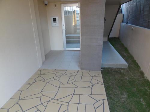 a hallway with a tile floor in a building at Weekly Harbourview Mansion Ginowan in Ginowan